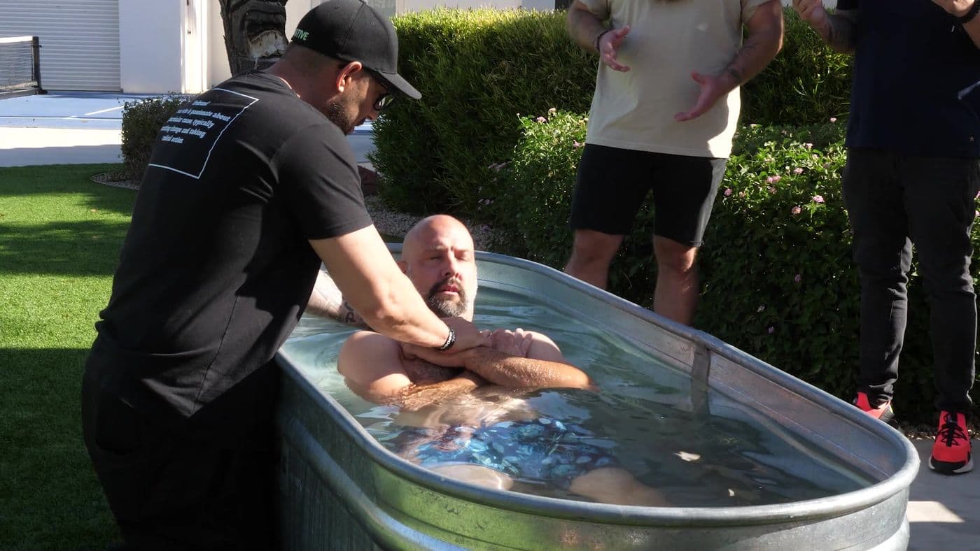 A man being baptized in water, Firebrand men around him